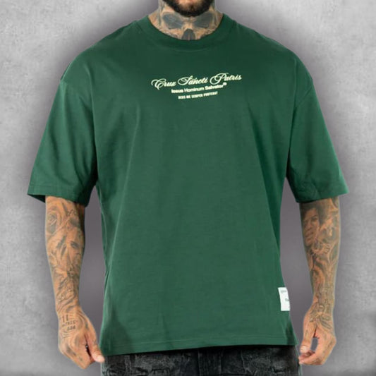 Esta es la Camiseta Oversize Stark – Crux Sacra Edition, una prenda con un simbolismo de fe y amuleto. El fit oversize es perfecto para un look moderno y relajado. El gráfico detallado de la medalla en blanco y el color verde intenso de la tela crean un contraste visual llamativo. Es la camiseta ideal para quienes buscan un diseño que ofrezca protección y un toque de misterio, fusionando la iconografía religiosa con el estilo de la moda urbana.