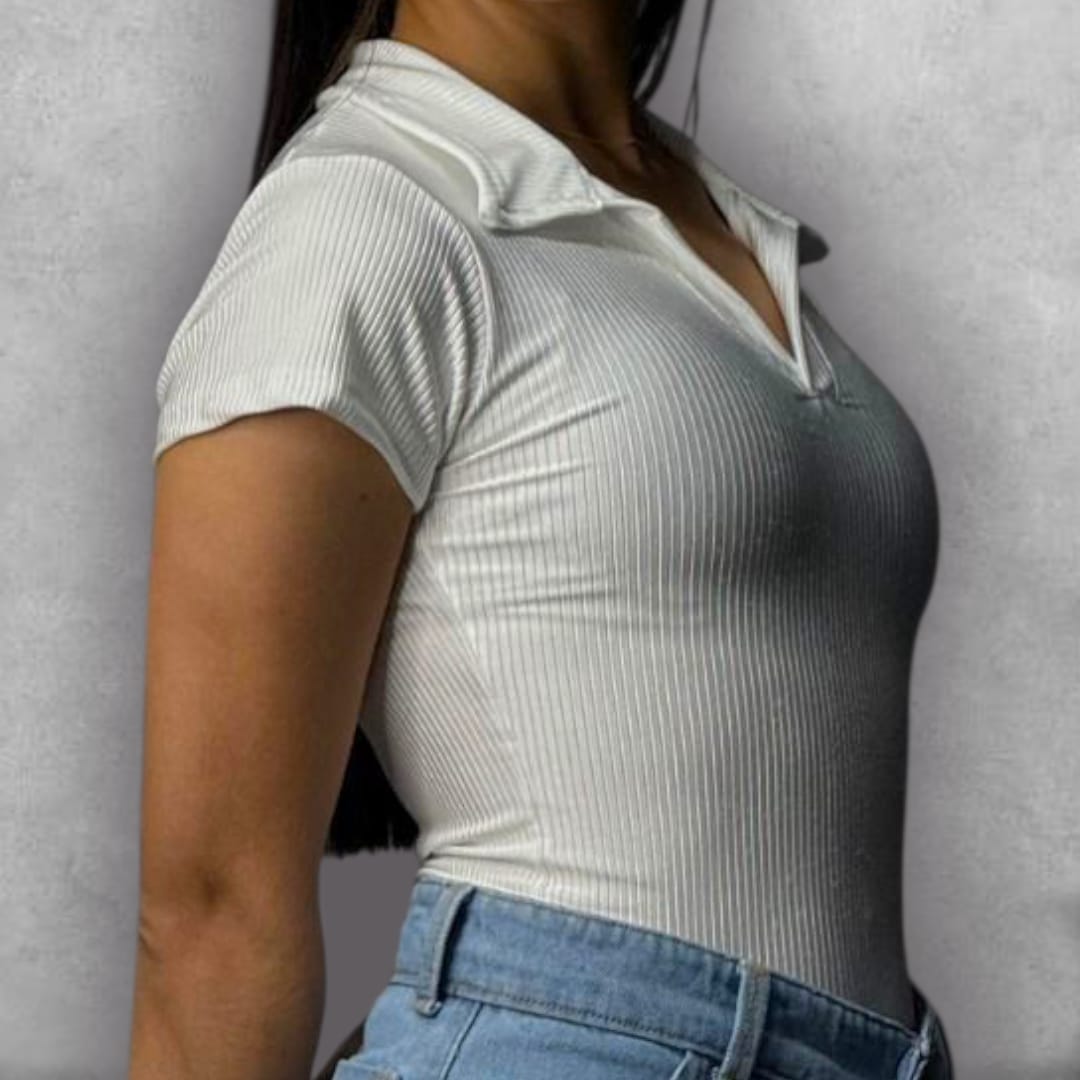 Añade un toque sofisticado a tus básicos de verano con el Body Clamford – White Polo Edition. Su construcción acanalada en blanco puro ofrece una textura sutil que eleva la prenda. El detalle del cuello tipo polo con el escote en V le da un giro moderno al diseño de manga corta. Esta pieza ajustada es clave para lograr una silueta impecable, manteniendo un estilo elegante y contemporáneo.