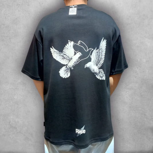Consigue la ligereza del estilo con la Camiseta Oversize Rise – Freedom Flight Edition. Esta prenda negra de ajuste oversize es el lienzo perfecto para el gráfico minimalista de dos palomas, que representa la conexión y el movimiento ascendente. Es la camiseta ideal para un look relajado, ofreciendo una comodidad superior sin renunciar a un diseño que comunica tranquilidad y propósito. Una pieza esencial para elevar tus básicos urbanos.