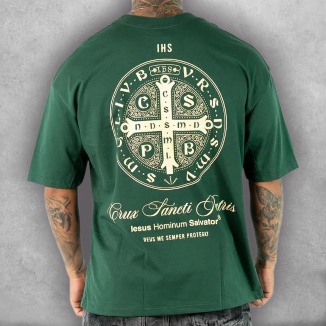 Esta es la Camiseta Oversize Stark – Crux Sacra Edition, una prenda con un simbolismo de fe y amuleto. El fit oversize es perfecto para un look moderno y relajado. El gráfico detallado de la medalla en blanco y el color verde intenso de la tela crean un contraste visual llamativo. Es la camiseta ideal para quienes buscan un diseño que ofrezca protección y un toque de misterio, fusionando la iconografía religiosa con el estilo de la moda urbana.
