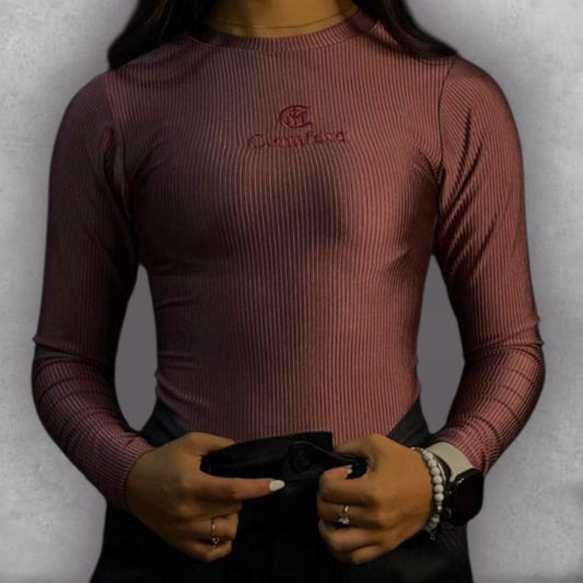 Descubre la versatilidad con el Body Clamford – Ribbed Elegance Edition. Su tejido elástico acanalado no solo es cómodo, sino que crea una textura visualmente rica en su hermoso color vino. El diseño de manga larga y cuello alto proporciona una cobertura elegante y es perfecto para transicionar entre estaciones. El bordado frontal minimalista de Clamford asegura un estilo pulido y chic. Es la pieza imprescindible para lograr un look de tendencia sin esfuerzo, pasando de casual a formal con los accesorios co
