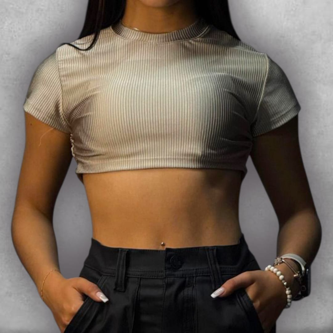 Añade elegancia discreta a tus looks con el Croptop Clamford – Sand Ribbed Edition. El tejido elástico acanalado no solo es cómodo, sino que su color beige le da una apariencia limpia y de alta calidad. El diseño crop y la manga corta son perfectos para el clima cálido, mientras que el cuello alto asegura un acabado pulido. Es la elección ideal para quienes buscan un básico con una textura rica y un color atemporal que nunca pasa de moda.