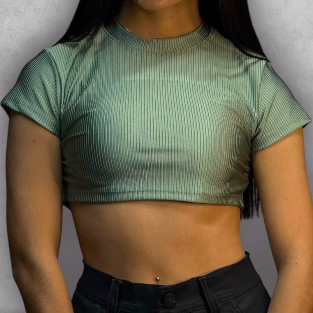 Añade un toque de tendencia a tus básicos con el Croptop Clamford – Mint Ribbed Edition. El tejido elástico acanalado no solo es increíblemente cómodo, sino que le da una textura visualmente rica a su color verde claro. El diseño crop y la manga corta lo hacen perfecto para el clima cálido, mientras que el cuello alto asegura un look pulido y versátil. Es la elección ideal para un estilo urbano que busca la comodidad sin sacrificar la sofisticación.