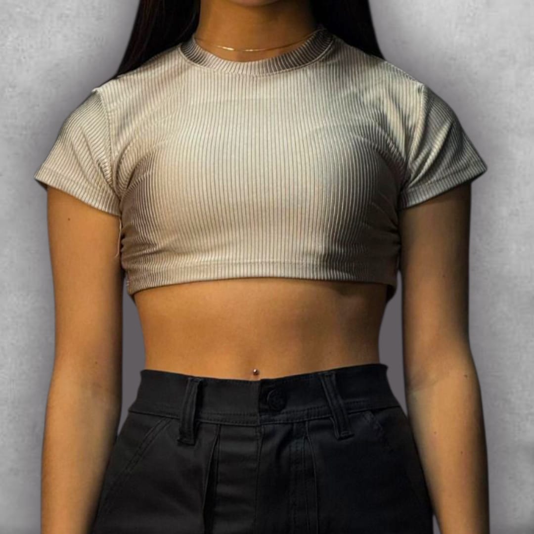 Añade elegancia discreta a tus looks con el Croptop Clamford – Sand Ribbed Edition. El tejido elástico acanalado no solo es cómodo, sino que su color beige le da una apariencia limpia y de alta calidad. El diseño crop y la manga corta son perfectos para el clima cálido, mientras que el cuello alto asegura un acabado pulido. Es la elección ideal para quienes buscan un básico con una textura rica y un color atemporal que nunca pasa de moda.