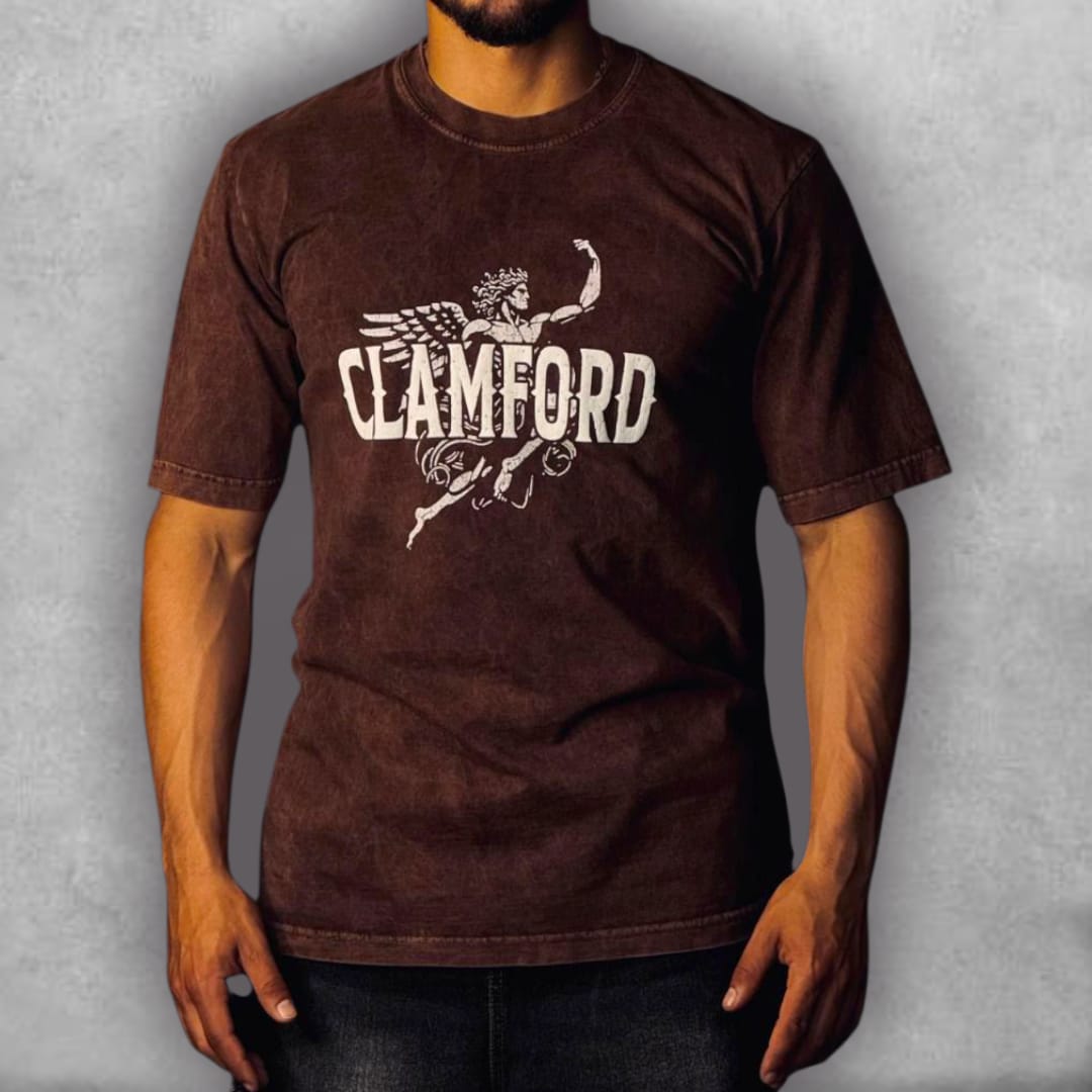 La Camiseta Semioversize Clamford – Mythic Warrior Edition es una pieza de arte épico. Sobre el color marrón oscuro con efecto acid wash, el impactante diseño trasero presenta un guerrero alado de estética clásica enmarcado en un círculo celestial de estrellas y símbolos. La palabra "CLAMFORD" en mayúsculas blancas domina la parte superior, mientras que un texto en la base habla de gratitud y encomendar todo a una fuerza superior. Su corte semioversize ofrece un equilibrio entre comodidad y una silueta estr