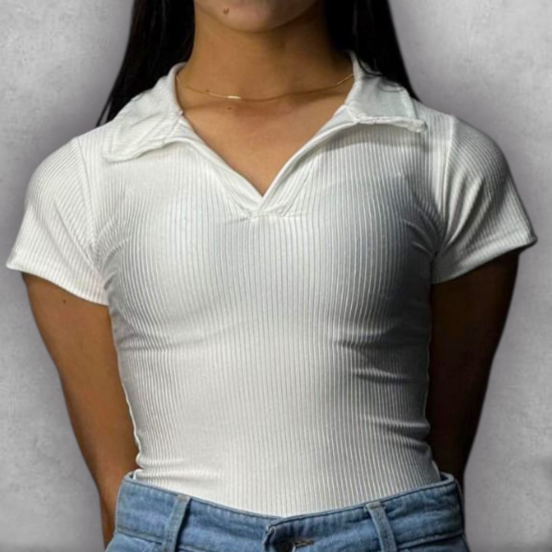 Añade un toque sofisticado a tus básicos de verano con el Body Clamford – White Polo Edition. Su construcción acanalada en blanco puro ofrece una textura sutil que eleva la prenda. El detalle del cuello tipo polo con el escote en V le da un giro moderno al diseño de manga corta. Esta pieza ajustada es clave para lograr una silueta impecable, manteniendo un estilo elegante y contemporáneo.