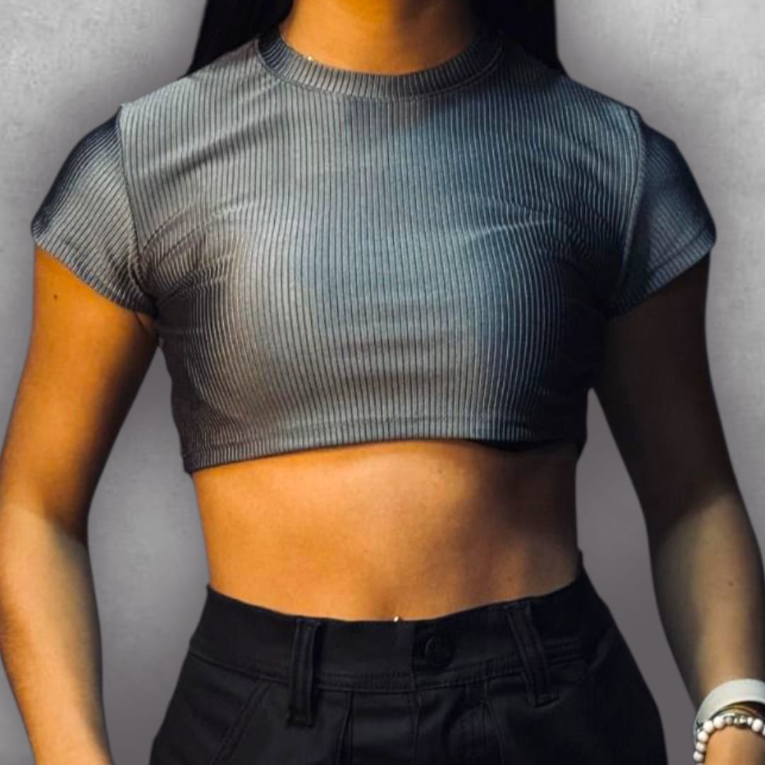 Consigue un look audaz y moderno con el Croptop Clamford – Steel Ribbed Edition. El tejido elástico acanalado no solo es cómodo, sino que su color gris metálico lo convierte en una pieza que atrae miradas. El diseño crop y la manga corta lo hacen perfecto para los días cálidos o para superposiciones, mientras que el cuello alto asegura un acabado pulido. Es la elección perfecta para quienes buscan un básico con una diferencia notable en textura y color.